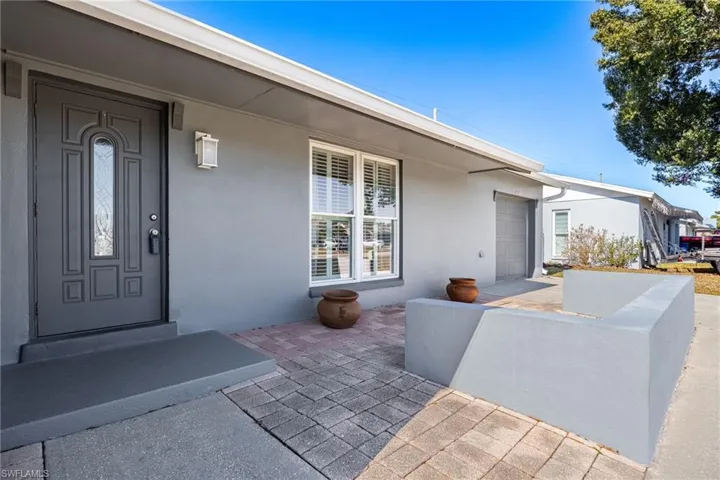 View of exterior entry featuring stucco siding and a garage