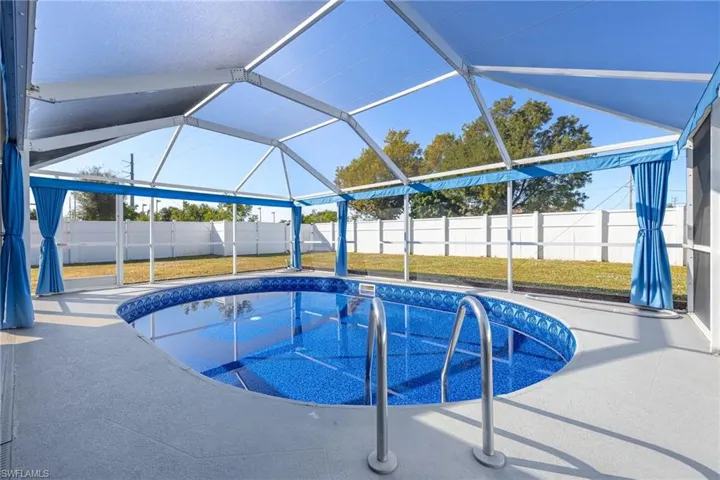 View of swimming pool featuring glass enclosure, a sunroom, and a fenced backyard