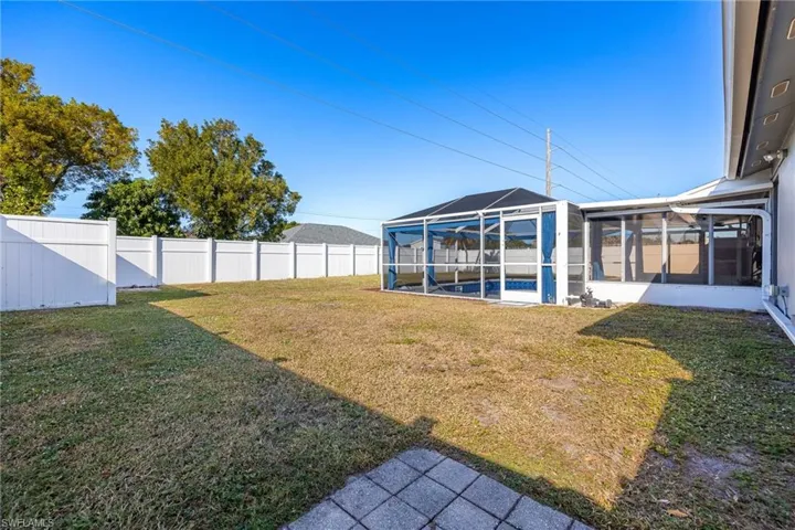 Fenced backyard with glass enclosure, a sunroom, and a swimming pool