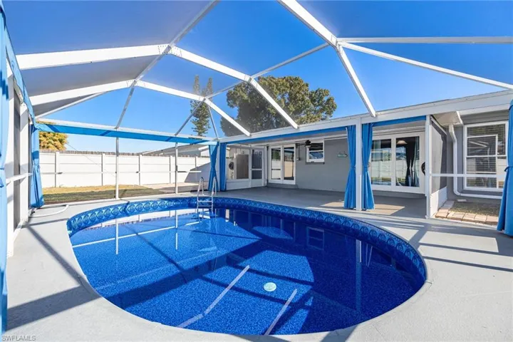 View of pool featuring a sunroom, a lanai, and a patio