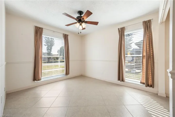 Spare room featuring ceiling fan, a textured ceiling, and light tile patterned floors