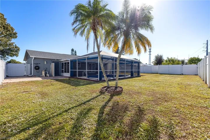 Rear view of property with a fenced backyard, a lanai, and a sunroom