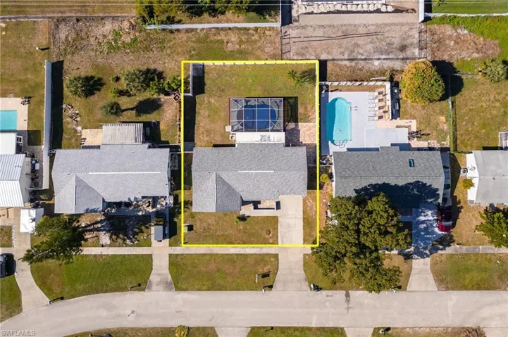 Aerial perspective of suburban area featuring property boundaries highlighted and a pool area