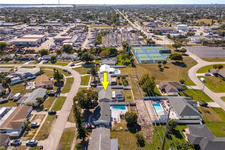 Aerial overview of property's location with nearby suburban area and a pool