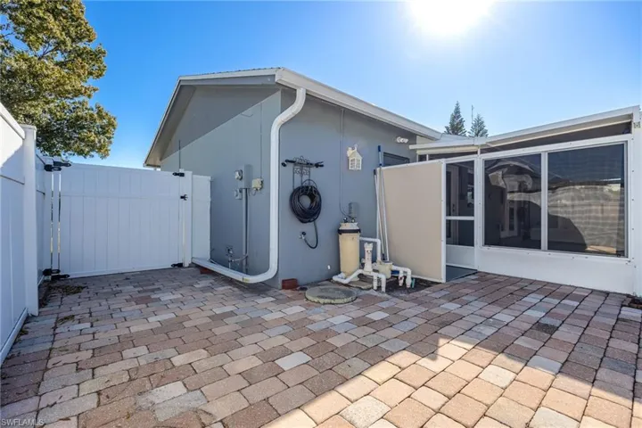 Rear view of house with a gate, a patio, and stucco siding