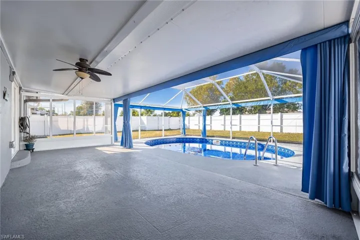 View of pool with a lanai, a sunroom, a fenced backyard, and a patio area