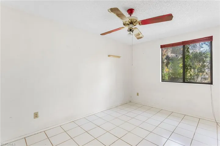 Spare room featuring a textured ceiling, a ceiling fan, and light tile patterned flooring