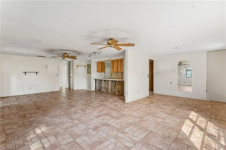 Unfurnished living room featuring a textured ceiling and a ceiling fan