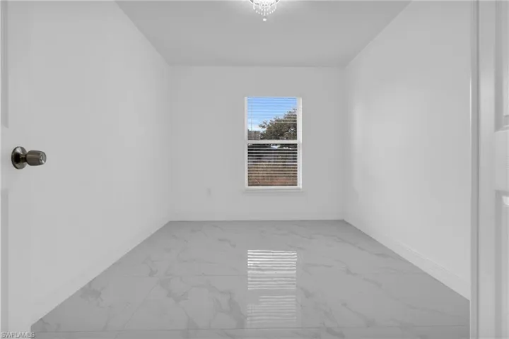 Empty room featuring light marble finish floors and baseboards