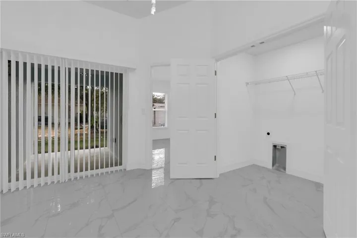 Laundry area with light marble finish flooring and electric dryer hookup