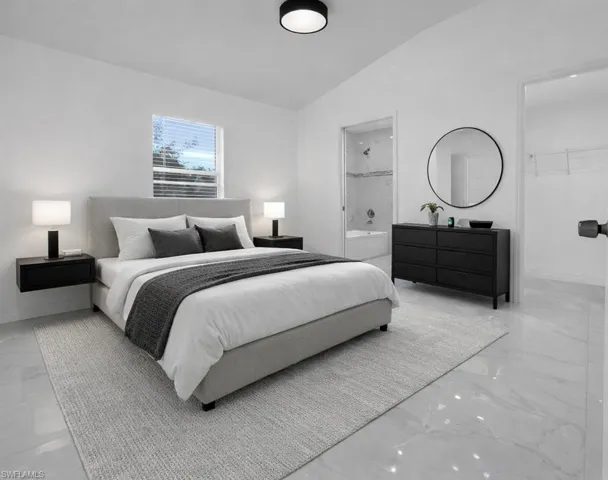 Bedroom with vaulted ceiling and marble tiled flooring