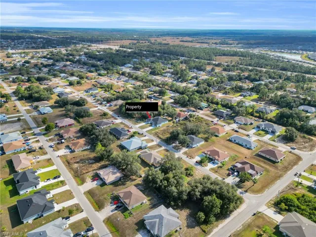 Aerial view of property and surrounding area with nearby suburban area