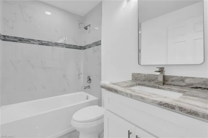 Full bath featuring washtub / shower combination and vanity