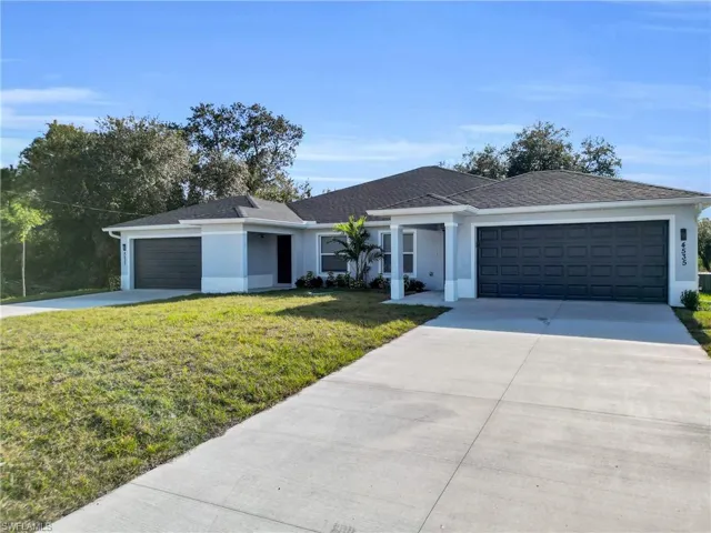 Ranch-style home with stucco siding, a front yard, and a garage