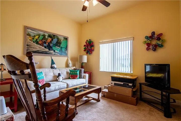 Living room with carpet and ceiling fan