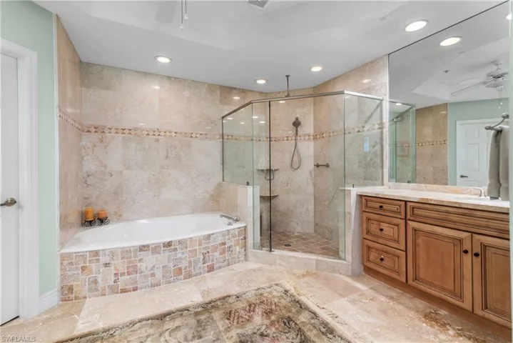 Bathroom with independent shower and bath, vanity, ceiling fan, and tile patterned flooring