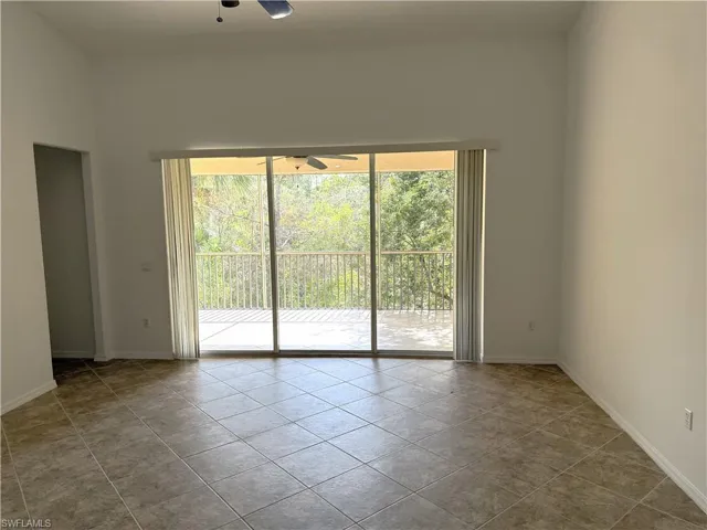 Empty room featuring ceiling fan and light tile patterned flooring