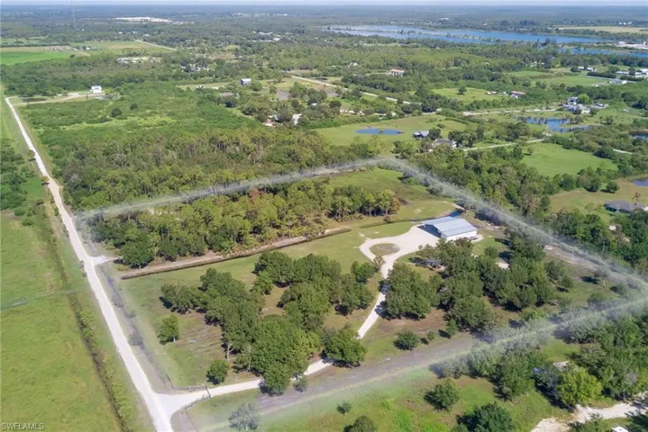 Aerial view of property and surrounding area featuring a forest