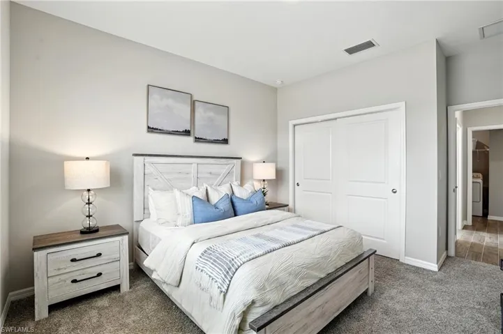 Bedroom with carpet floors, a closet, and washer / clothes dryer