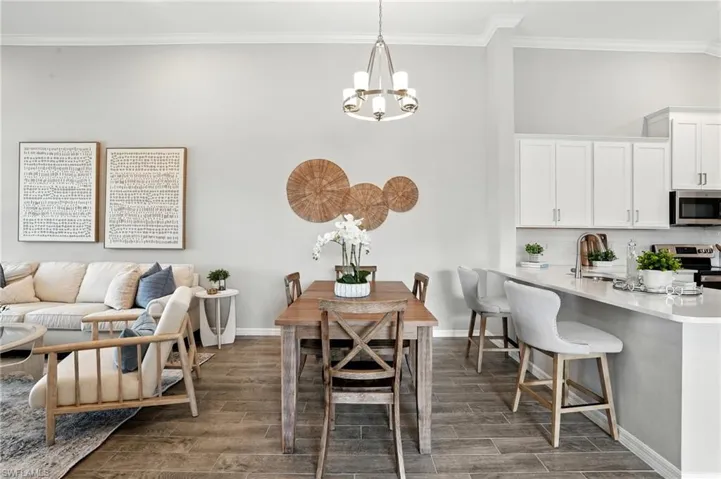 Dining space featuring crown molding, wood tiled floors, and a chandelier