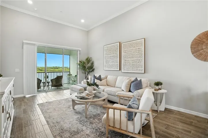 Living room with a water view, crown molding, wood tiled floors, and recessed lighting