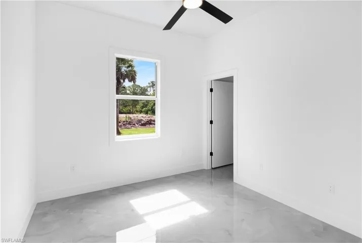 Empty room featuring ceiling fan and light marble finish flooring