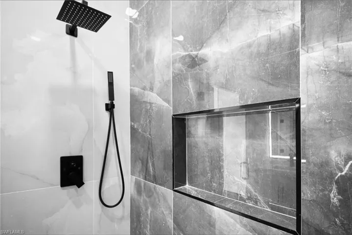 Full bath featuring a marble finish shower