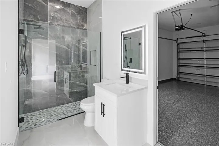 Bathroom with vanity and a marble finish shower