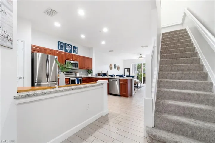 Entry splits to kitchen and living area, and stairs to bedrooms
