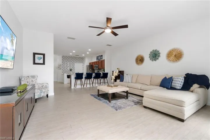 Living room featuring wood-like tile floors, fresh paint and ceiling fan