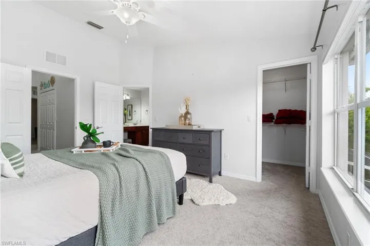 Bedroom with carpet, ceiling fan, and a walk in closet