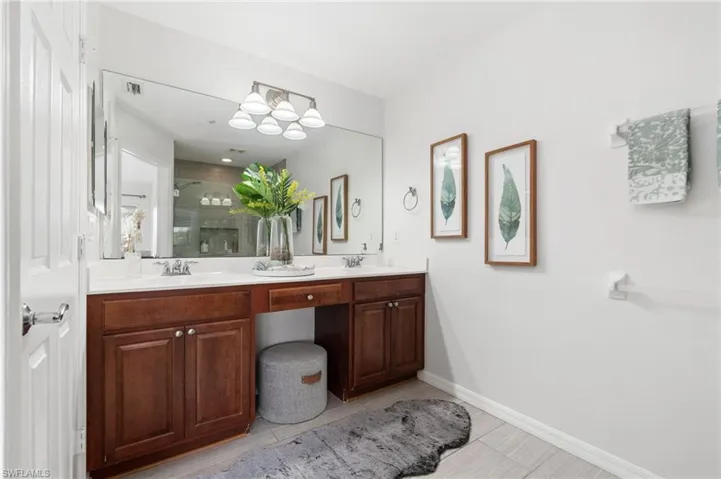 Primary bathroom featuring tile patterned floors and dual bowl vanity