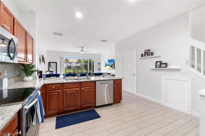 Kitchen with appliances with stainless steel finishes,decorative backsplash, light stone countertops