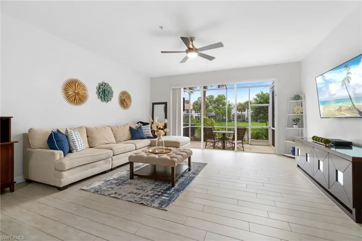 Living room featuring wood-like tile floors, fresh paint and ceiling fan