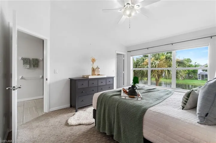 Primary bedroom featuring ceiling fan and vaulted ceiling
