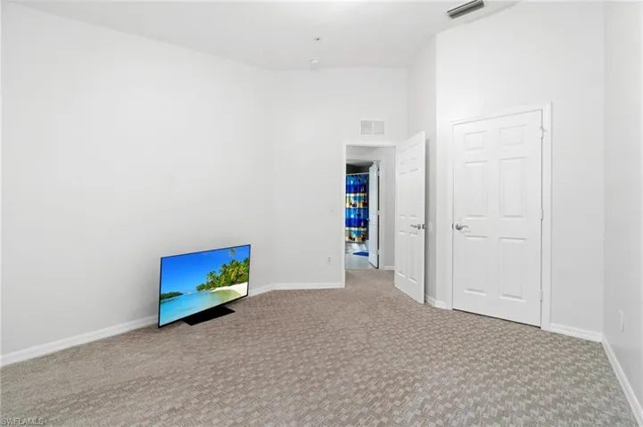 Guest bedroom 2 featuring carpet floors and a high ceiling