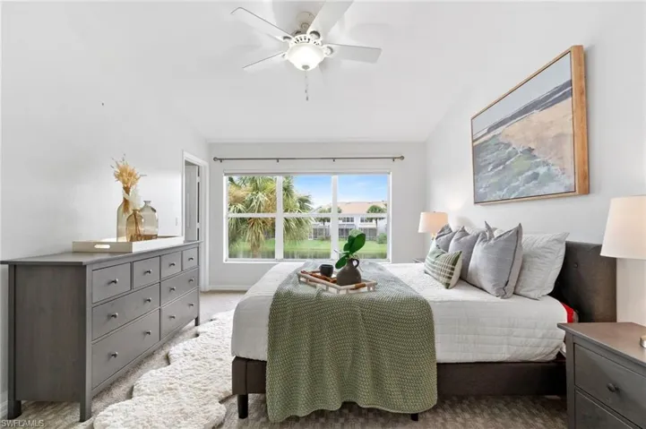 Primary bedroom featuring carpet, ceiling fan, and lofted ceiling