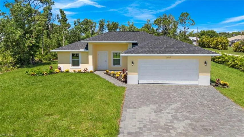 Ranch-style house featuring a front yard and a garage