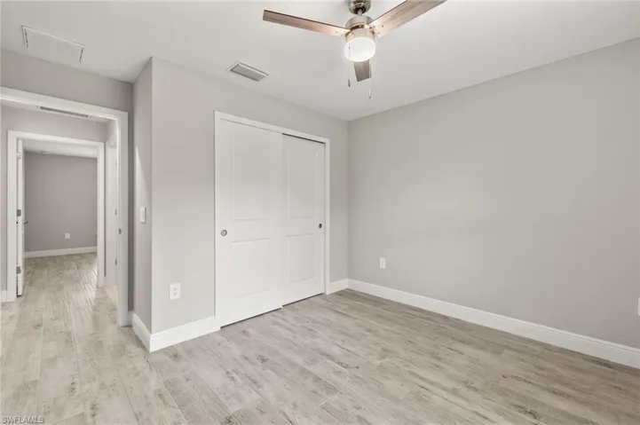 Unfurnished bedroom featuring a closet, ceiling fan, and light hardwood / wood-style flooring