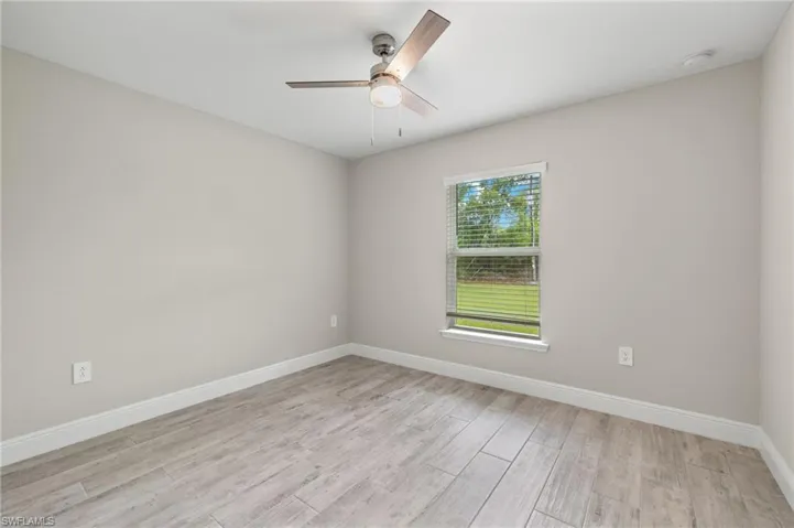 Unfurnished room featuring ceiling fan and light hardwood / wood-style flooring