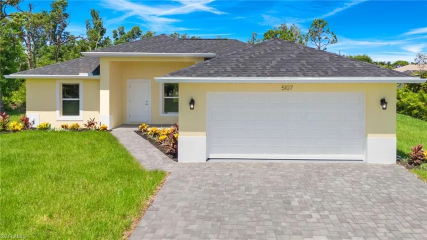 View of front of property featuring a garage and a front yard