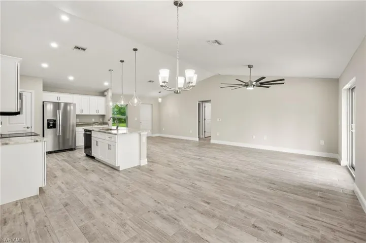 Kitchen with white cabinetry, stainless steel fridge, and light hardwood / wood-style floors