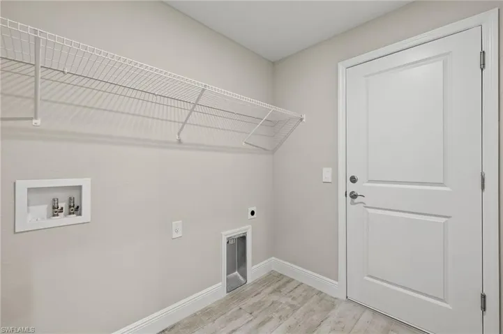 Laundry area featuring hookup for a washing machine, hookup for an electric dryer, and light wood-type flooring