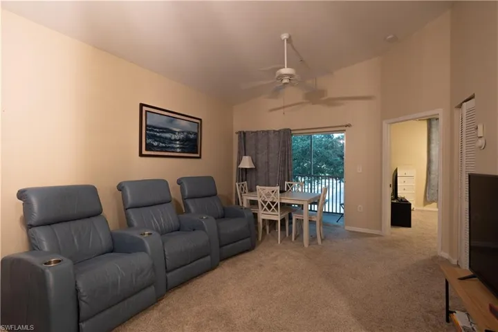 Home theater featuring high vaulted ceiling, ceiling fan, and carpet floors