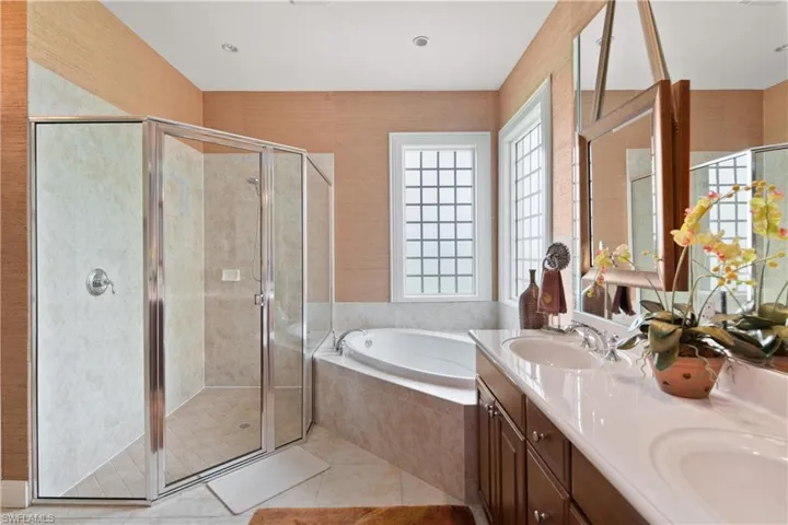 Bathroom with independent shower and bath, double sink vanity, and tile patterned flooring