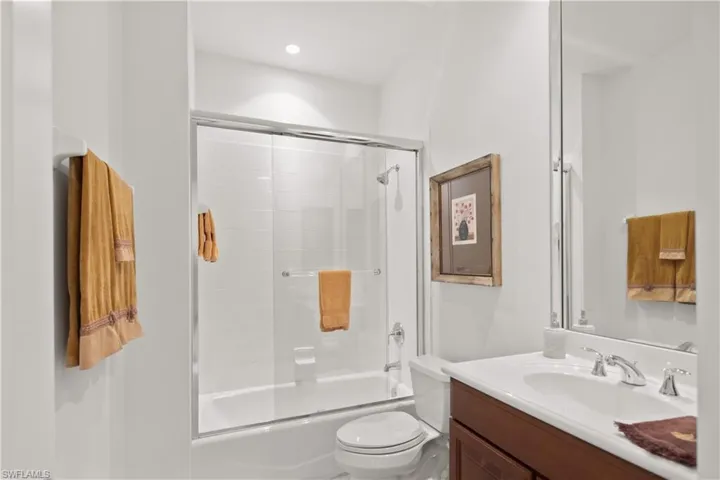 Full bathroom with vanity, toilet, and enclosed tub / shower combo