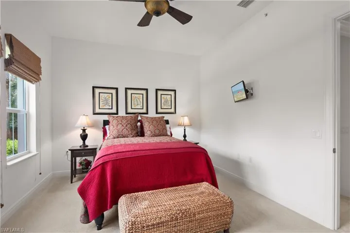 Carpeted bedroom featuring ceiling fan