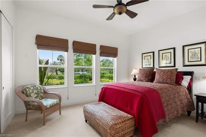 Bedroom with ceiling fan, light carpet, and a closet