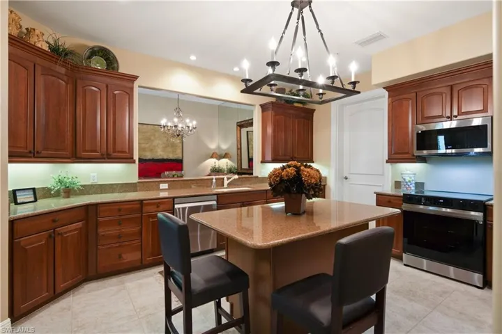Kitchen featuring a kitchen bar, appliances with stainless steel finishes, kitchen peninsula, and light tile patterned floors