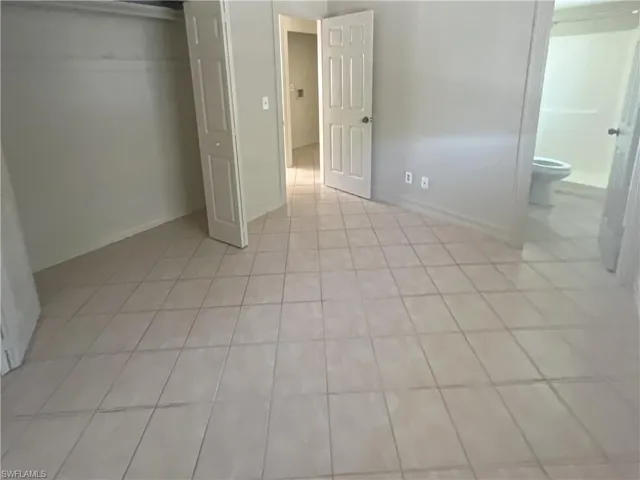 Unfurnished bedroom with light tile patterned flooring and a closet